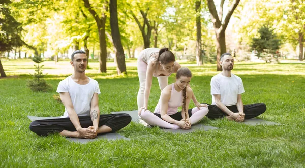 Персональный тренер по йоге, помогающий повысить гибкость ее ученицы — стоковое фото