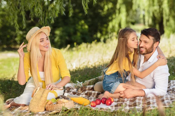 Un picnic familiar. hija besar padre en mejilla —  Fotos de Stock