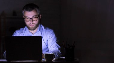 İşadamı karanlıkta dizüstü bilgisayar üzerinde çalışıyor