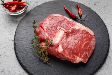 Siyah tahta üzerinde çiğ sığır pirzolası Parçası, closeup