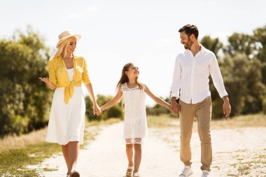 Mutlu aile el ele tutuşarak yolda yürüyor