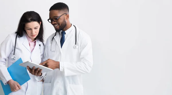 Dwóch lekarzy w białych płaszcze omawia diagnozę — Zdjęcie stockowe