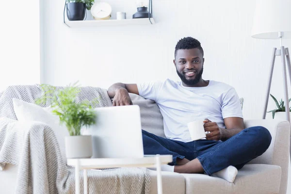 Millennial chico disfrutando de café de la mañana y noticias en el ordenador portátil — Foto de Stock