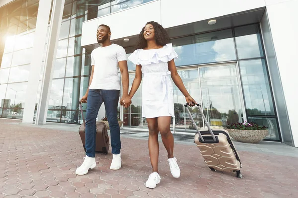 Щаслива чорна пара, що йде перед будівлею терміналу аеропорту — стокове фото