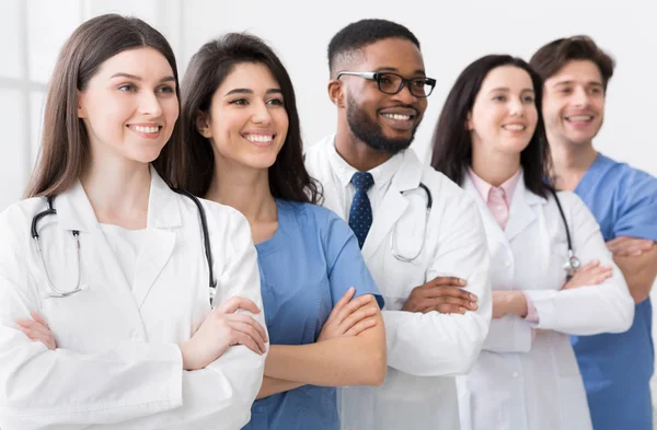 Equipo diverso de médicos posando en el hospital en fila — Foto de Stock