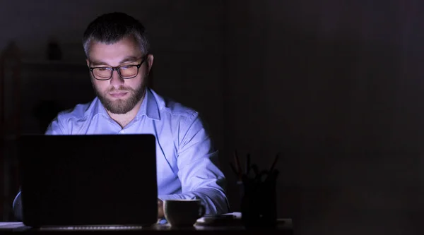Ο επιχειρηματίας εργάζεται στο φορητό υπολογιστή στο σκοτάδι — Φωτογραφία Αρχείου