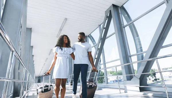 Miłośnicy Afryki podróżować, kochający para chodzenie na lotnisku z walizkami — Zdjęcie stockowe
