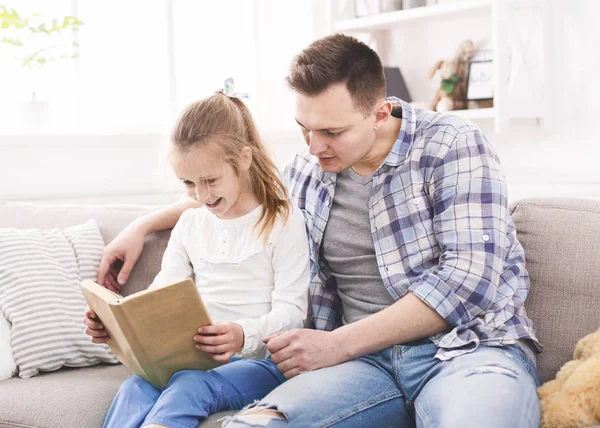 Upphetsad flicka och hennes far njuter bok tillsammans — Stockfoto