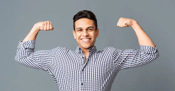 Positiv ung man visar biceps och leende på kamera — Stockfoto