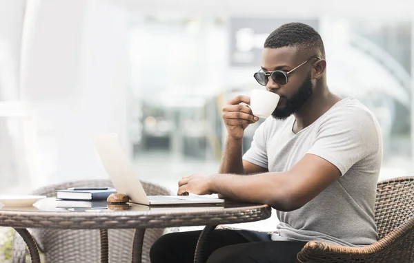 Κομψός αφρικανός τύπος πίνοντας πρωινό καφέ και διαβάζοντας βιβλίο — Φωτογραφία Αρχείου