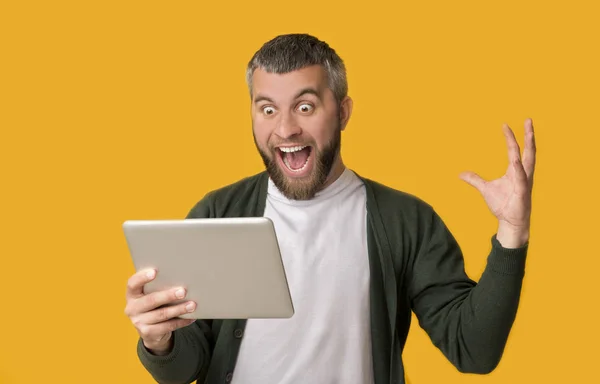 Homem barbudo excitado segurando tablet e gritando — Fotografia de Stock