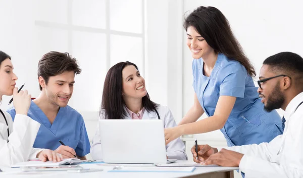 Practitioners and interns discussing medical reports on laptop — Stock Photo, Image