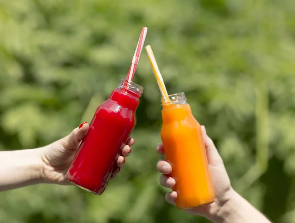 Best friends drinking refreshing red and orange detox cocktails — Stock Photo, Image