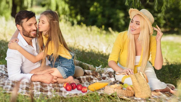 Una familia encantadora en el picnic. hija besar padre en mejilla — Foto de Stock