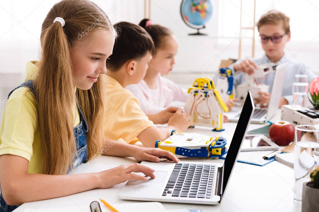 Stem education. Girl programming diy robot with laptop