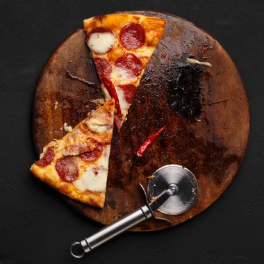 Ahşap kesme tahtası üzerinde pepperoni pizza birkaç dilim