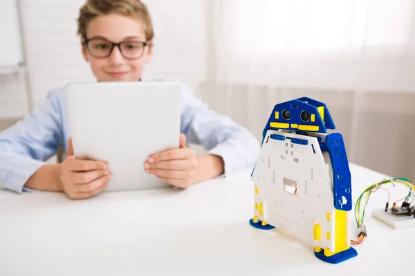 Robot de programmation garçon avec tablette en classe — Photo