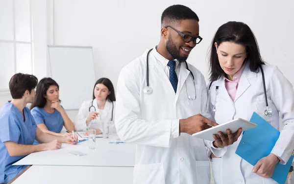 Afro médecin donner des conseils à son collègue lors de la réunion — Photo