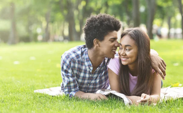 Susurrando sobre el amor. Románticos adolescentes acostados en la hierba al aire libre —  Fotos de Stock