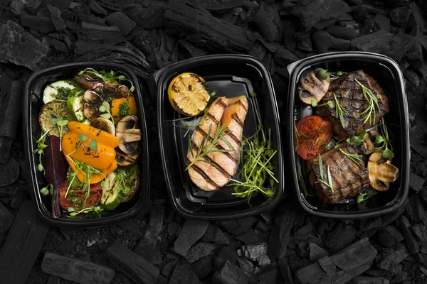 Grilled restaurant food in take away boxes for each person