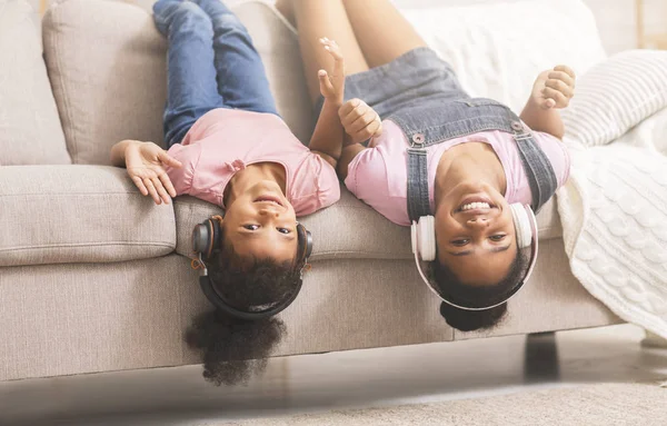 Підлітки і маленькі чорні дівчата насолоджуються музикою в навушниках — стокове фото