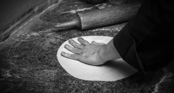 Chef rolling dough for round pizza, closeup — Stock Photo, Image