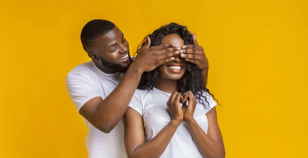 Afro man staande achter zijn vrouw en het sluiten van haar ogen — Stockfoto