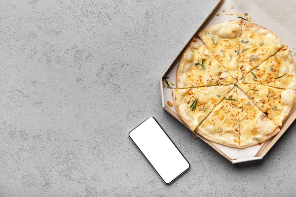 Сирна піца в коробці доставки і смартфон з порожнім екраном — стокове фото