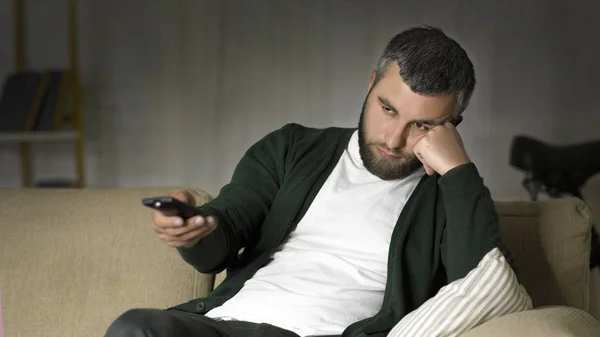 Vervelen man Schakel kanalen op TV thuis — Stockfoto