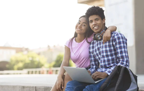 Tiener paar met behulp van laptop buitenshuis poseren naar camera — Stockfoto