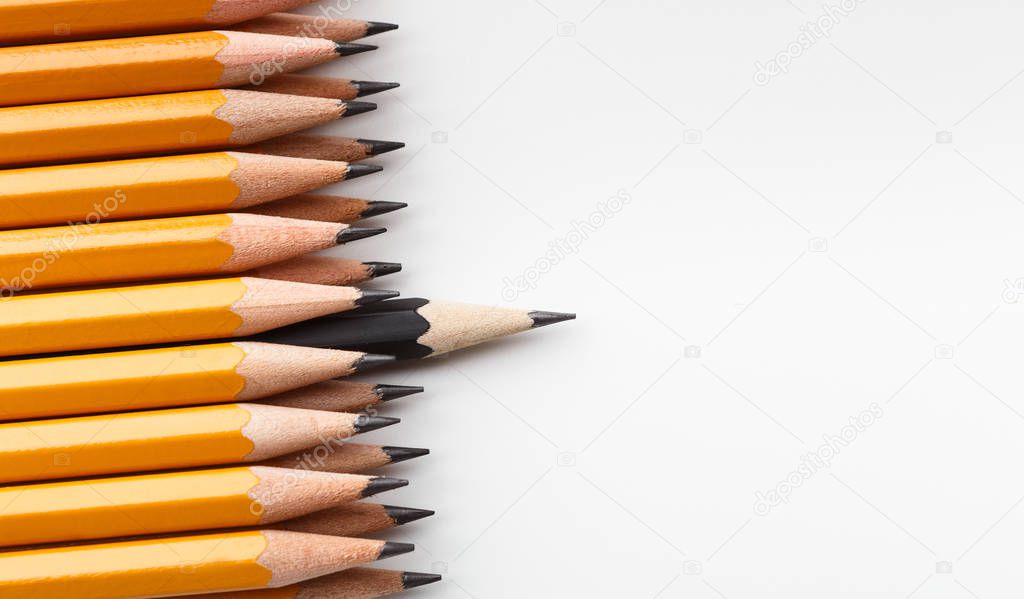 One black pencil sticking out of identical ones
