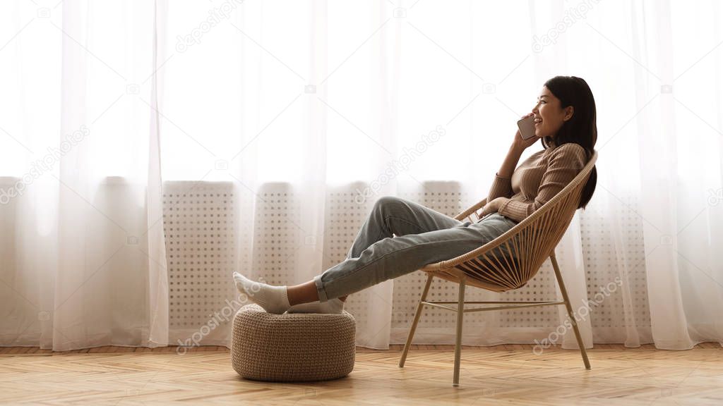 Girl Resting in Armchair and Talking on Phone