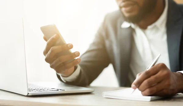 Empresário afro-americano observando informações do celular — Fotografia de Stock