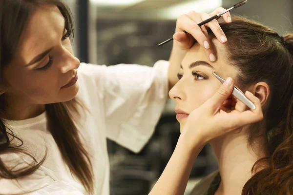 Brow Artist Plucking And Shaping Girls Brows in Beauty Studio — стоковое фото