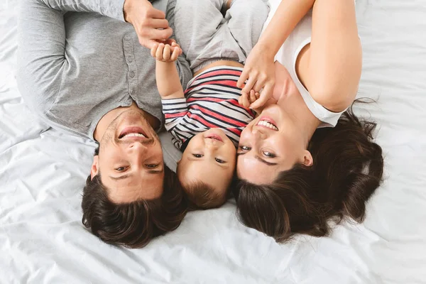 Jovem mãe feliz e pai abraçando com o bebê bonito filho — Fotografia de Stock