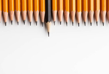 Row of classic yellow pencils with one black protruding clipart