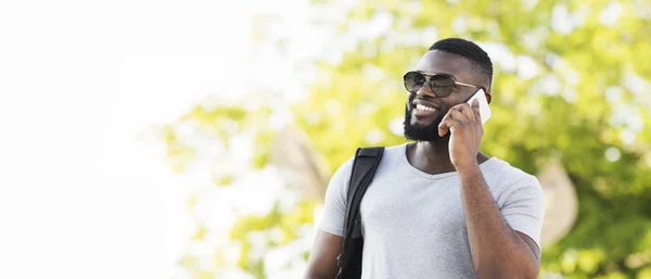 Портрет стильного африканського чоловіка в сонцезахисних окулярах, що розмовляють по телефону — стокове фото
