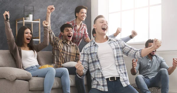 Podekscytowani przyjaciele bawią się oglądając mecz piłki nożnej w domu — Zdjęcie stockowe