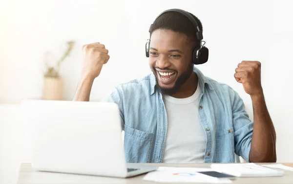 Siyah erkek freelancer başarılı online görüşme tamamlayarak kutluyor — Stok fotoğraf
