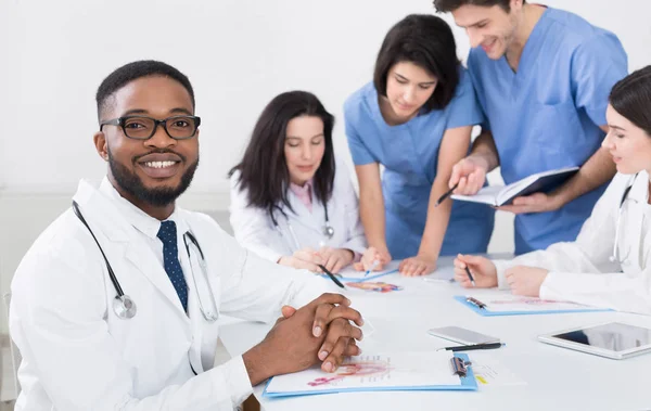 Profesionales y pasantes en reunión en consultorio médico —  Fotos de Stock