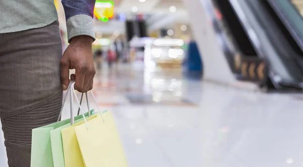 Unrecognizable african man holding shopping bags in city mall — Stock Photo, Image