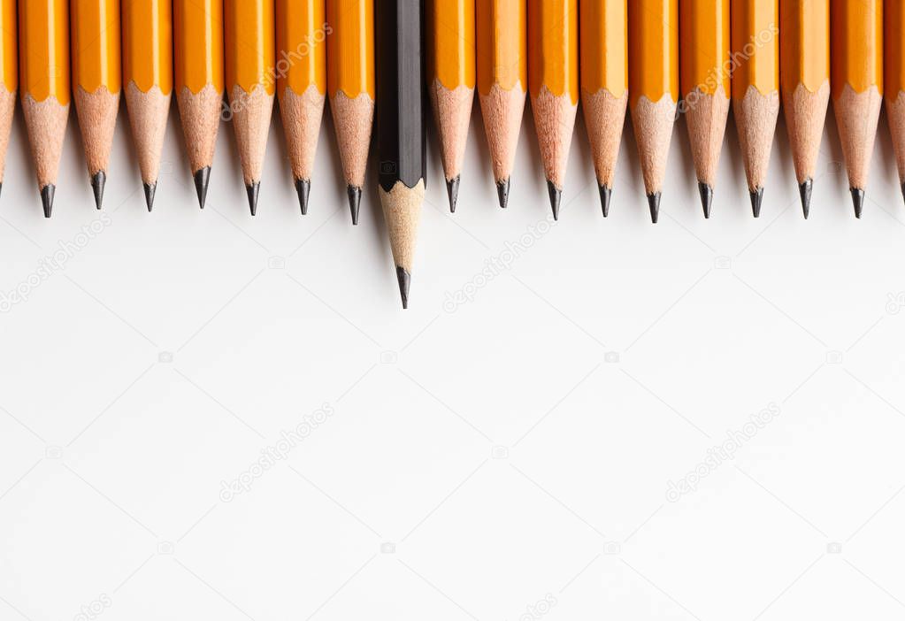 Row of classic yellow pencils with one black protruding