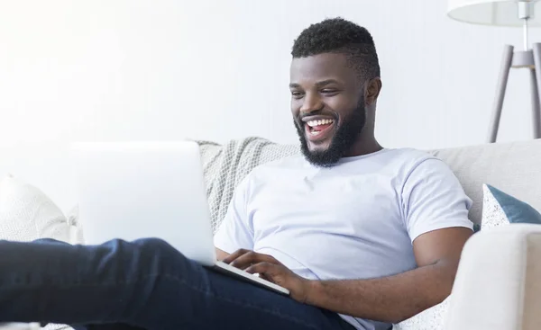 Mladý šťastný černoch oslavující úspěch s laptopem — Stock fotografie