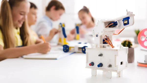 Enfants étudiant en classe avec robot au premier plan — Photo