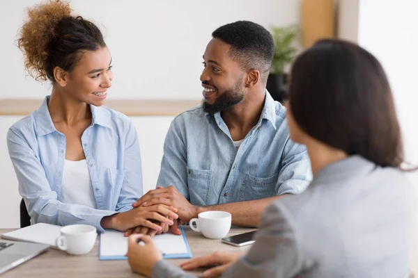 Smiling african american couple holding hands in financial advisors office — Stock Photo, Image