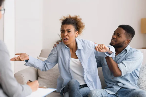 Mulher afro emocional acenando as mãos e culpando o marido durante a psicoterapia . — Fotografia de Stock