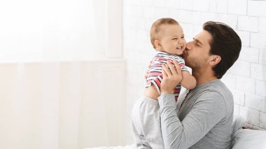 Genç adam onun sevimli bebek oğlu öpüşme, bebek bakımı zevk