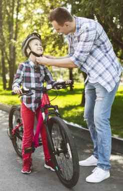 Cesur kız bisiklete binmeyi öğreniyor.