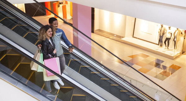 African couple having after shopping coffee in mall