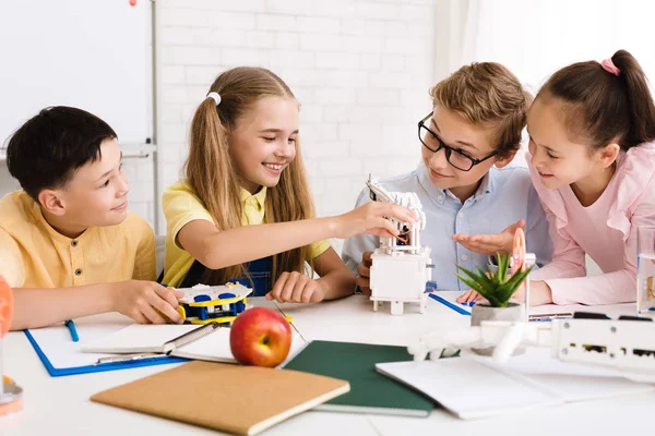 Gelukkige kinderen maken robots bij de les samen — Stockfoto